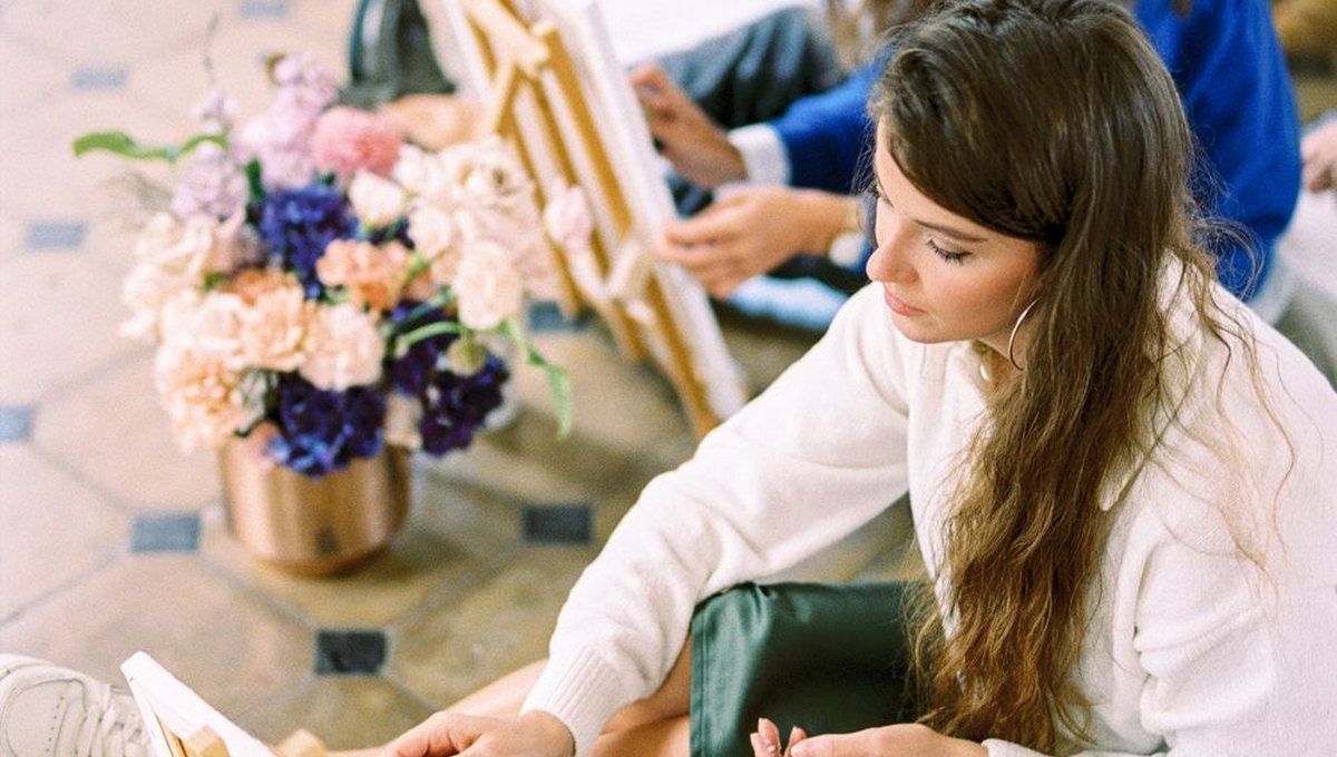 Person painting at a creative workshop with face fully visible (illustrative stock photo)